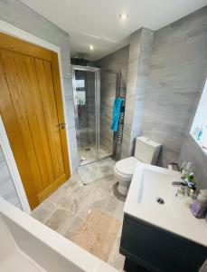 uma casa de banho com um WC, um lavatório e um chuveiro em Whiteclouds em Cheshunt
