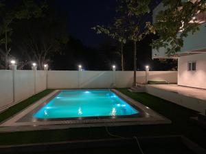 a swimming pool in a backyard at night at Dlr Tranquilla in Hyderabad