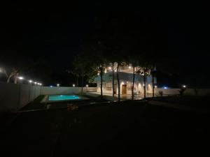 a building with a swimming pool at night at Dlr Tranquilla in Hyderabad