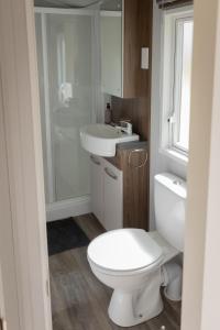 ein Badezimmer mit einer weißen Toilette und einem Waschbecken in der Unterkunft Vakantiehuis Hoge Kempen - 25 minuten Roermond, Maasmechelen & Maastricht in Kinrooi + 18 Fotos