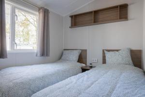 dos camas sentadas una al lado de la otra en un dormitorio en Vakantiehuis Hoge Kempen - 25 minuten Roermond, Maasmechelen & Maastricht, en Kinrooi