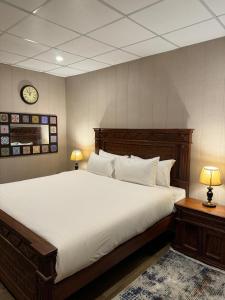 a bedroom with a large bed with a clock on the wall at Infinity Villa and Resort Kumrat Valley in Tāl +30 photos