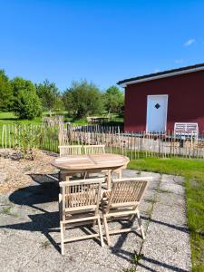 a wooden table and two chairs and a table and a fence at Ferienhaus am Saaler Bodden in Saal