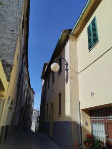 um beco entre dois edifícios com uma luz de rua em Nuovo appartamento in borgo medievale em Grosseto