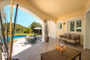 a patio with a table and chairs and a pool at Villa El Magraner by Abahana Villas in Benissa