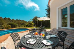 a black table with chairs next to a pool at Villa El Magraner by Abahana Villas in Benissa