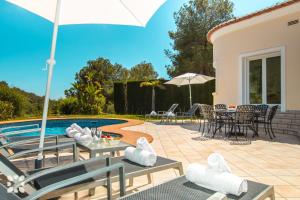 a patio with a table and chairs next to a pool at Villa El Magraner by Abahana Villas in Benissa