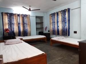 kolkata的住宿－Pushpak Guest House Boys, Near DumDum metro Station，带三张床和天花板的客房