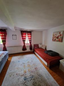 uma sala de estar com um sofá vermelho e duas janelas em Natur- & Erlebnis Ferienhaus em Voitsberg