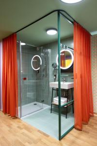 a bathroom with a glass shower with a sink at Schwarzes Rössl in St. Wolfgang