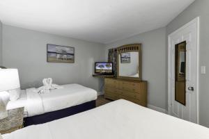 een hotelkamer met twee bedden en een spiegel bij Scenic Views from the balcony at Ocean Forest Plaza Condos in Myrtle Beach