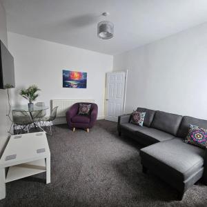 een woonkamer met een bank en een stoel bij Lyndhurst Place, Sunderland in Sunderland