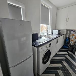 een keuken met een wasmachine en een wastafel bij Lyndhurst Place, Sunderland in Sunderland