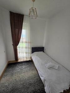 - une petite chambre avec un lit et une fenêtre dans l'établissement Dardania 2 Kastrati, à Prizren