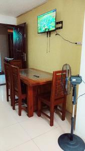 een tafel en stoelen met een ventilator en een tv aan de muur bij Nevada Place in Baguio