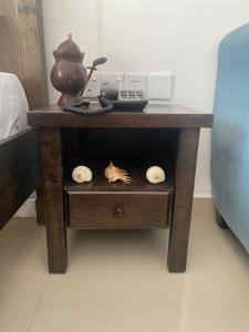 a wooden table with a phone and a telephone at Ocean Breeze Studio Apartment by Jayko in Negombo +22 photos