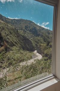 a view of a mountain from a window at Backpackers-balcones-river-lodge in Baños