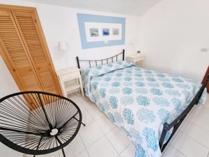 a bedroom with a bed with a blue and white comforter at Maridea - Via Dragonara in Ponza