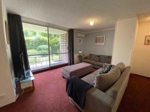 un soggiorno con un divano e una grande finestra di Quiet 2BR Apartment with Garden views in Griffith - Hosted by CanStay a Kingston 