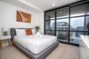 Kingston にあるCaptivating Lake Views in Kingston - Hosted by CanStayの白いベッドと大きな窓のある寝室