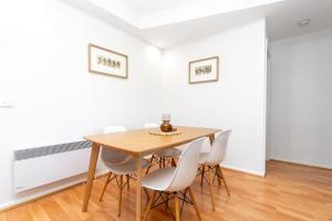 金斯顿2BR 2BA Apt with Dedicated Workspace and Free parking - Hosted by CanStay的一间带木桌和白色椅子的用餐室