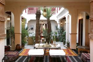 a courtyard with a table and chairs in a building at Riad Aladdin in Marrakesh