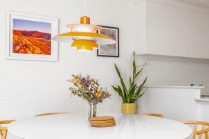 a dining room with a white table with a vase of flowers at Stylish apt facing the historic Telopea Park - Hosted by CanStay in Kingston 