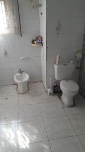 a white bathroom with a toilet and a bidet at Magodo Treat in Lagos +6 photos
