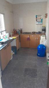 a kitchen with wooden cabinets and a blue bucket at Magodo Treat in Lagos