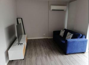 a living room with a blue couch and a tv at Cosy contemporary 1BR plus sofa bed - Hosted by CanStay in Canberra