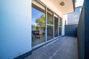 an outdoor patio with a table and glass windows at Cosy contemporary 1BR plus sofa bed - Hosted by CanStay in Canberra