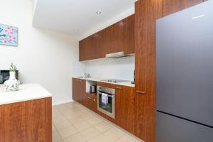 une cuisine avec des armoires en bois et un réfrigérateur dans l'établissement Absolutely spacious APT unit between ANU and City - Hosted by CanStay, à Canberra