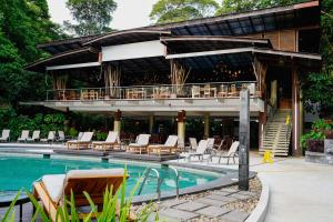 un complejo con piscina y tumbonas en Pachira Lodge, en Tortuguero