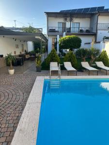 a blue swimming pool in front of a house at Garden Lounge Hotel in Yerevan