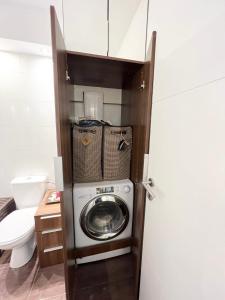 a washer and dryer in a bathroom with a toilet at Arena 23 Jacuzzi in Belgrade