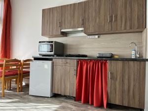 cocina con nevera blanca y toalla roja en Centr00m Apartman, en Dunaföldvár