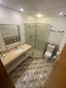 La salle de bains est pourvue d'une douche, de toilettes et d'un lavabo. dans l'établissement Flat Alphaville - ComfortSuites, à Barueri
