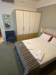 una camera con un grande letto e una sedia blu di Flat Alphaville - ComfortSuites a Barueri