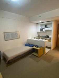 Habitación pequeña con cama y cocina en Flat Alphaville - ComfortSuites, en Barueri