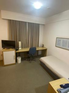 Habitación con escritorio, cama y ordenador. en Flat Alphaville - ComfortSuites, en Barueri