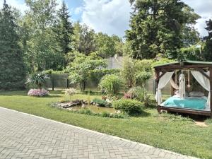a garden with a gazebo and a pond at Apartman Garden House in Voždivac