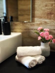 a bathroom with a vase of flowers and a towel at Zoe Luxury House in Gomirje