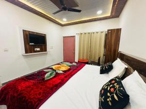 een slaapkamer met een bed met een rode deken erop bij Goroomgo The Ram Krishna Palace Ayodhya - Luxury Room in Ayodhya