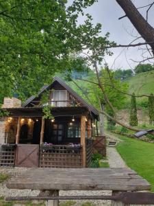 Jajce lake cottage-Plivsko jezero في يايتشه: منزل صغير مع شرفة وجسر خشبي