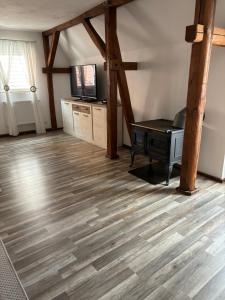 sala de estar con suelo de madera y escritorio en Ferienhaus Oliveira, en Spalt