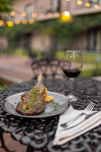 einen Teller Steak und ein Glas Wein auf dem Tisch in der Unterkunft Hotel Cubitá Boutique Resort & Spa in Chitré