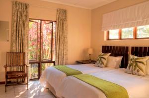 a bedroom with a large bed and a large window at The Musketeers Lodge in Bulawayo