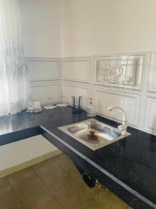 Una cocina con un fregadero en una encimera negra. en Heights Retreat - Galle, en Galle