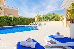 een villa met een zwembad en 2 ligstoelen bij Villa Esplendida by Abahana Villas in Calpe