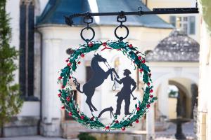 una corona di fiori di Natale appesa a un palazzo con un cavallo e un cavaliere di Schwarzes Rössl a St. Wolfgang